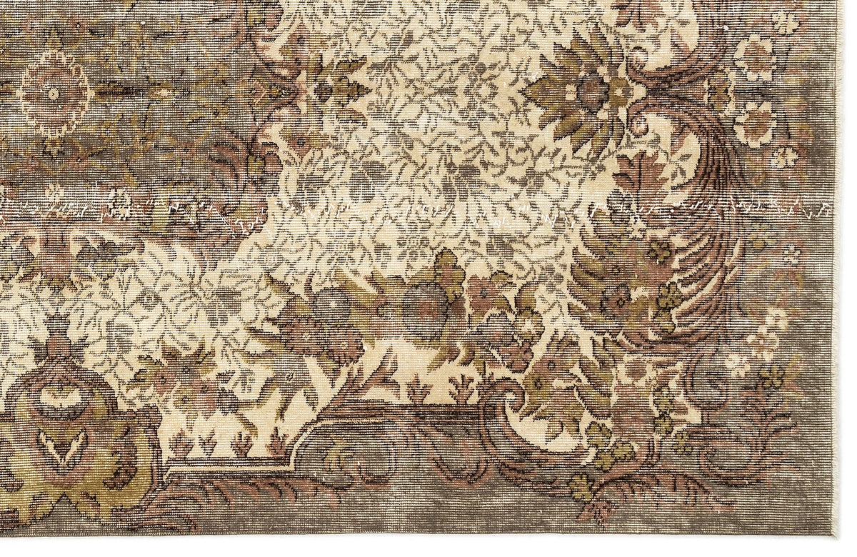 Distressed olive, brown, and cream rug with a traditional floral medallion pattern and ornate border.
