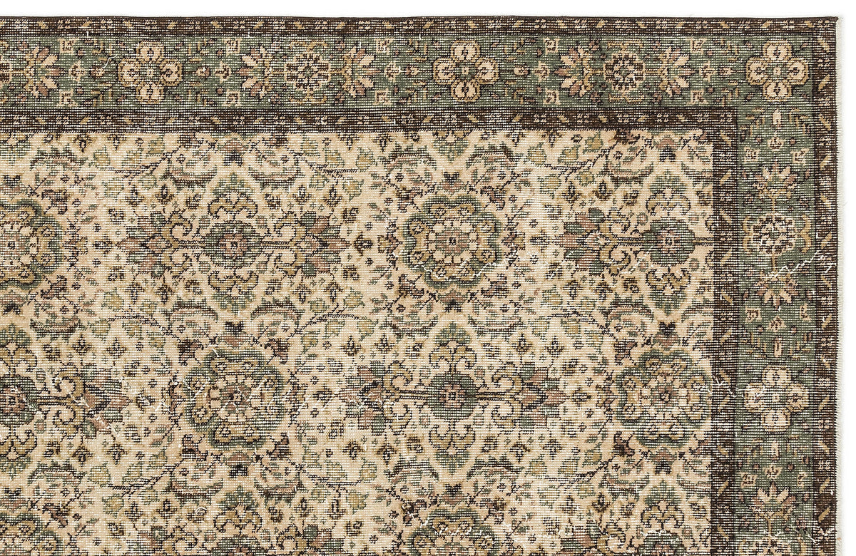 Sage green, brown, and cream traditional rug with a repeating floral medallion pattern and a wide decorative border.