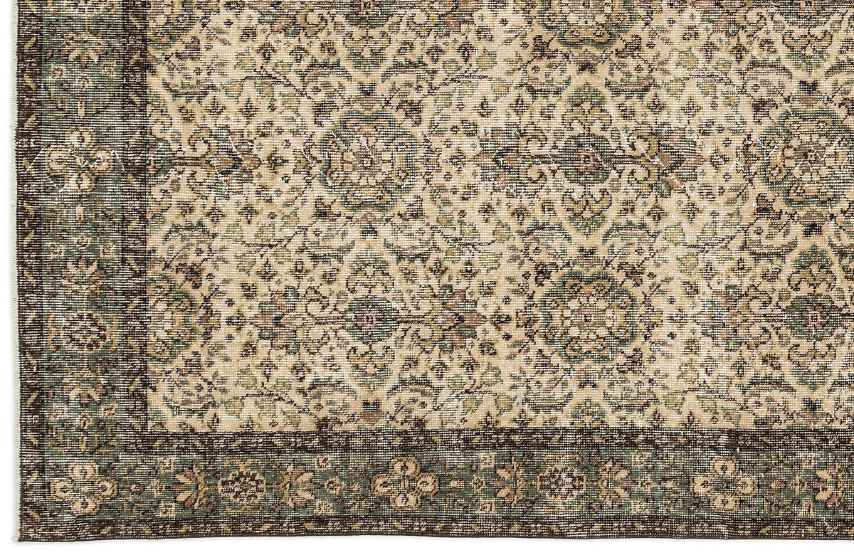 Beige, sage green, and dark brown traditional rug with a distressed floral medallion pattern and a wide border.