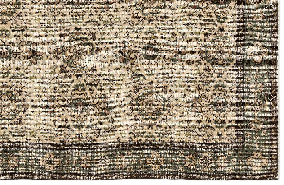 Beige and sage green traditional rug with a distressed floral medallion pattern and a dark brown border.