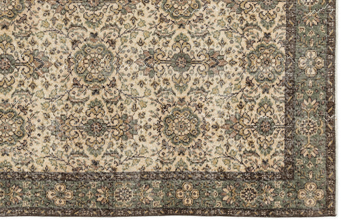 Load image 1 in gallery view. Beige and sage green traditional rug with a distressed floral medallion pattern and a dark brown border.