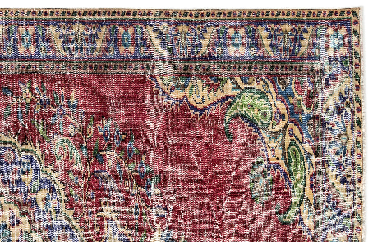 Distressed red traditional rug with blue, green, and beige floral paisley borders and central medallion motifs.