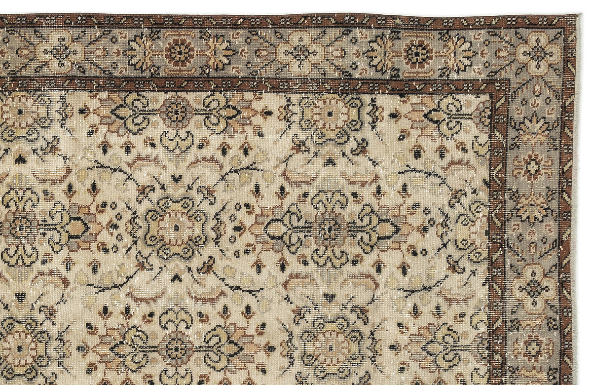 Beige, brown, and grey traditional rug with a distressed floral medallion pattern and a detailed border.
