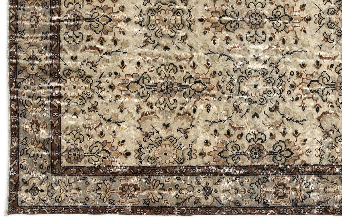 Beige and brown traditional rug with a distressed floral medallion pattern and a detailed geometric border.