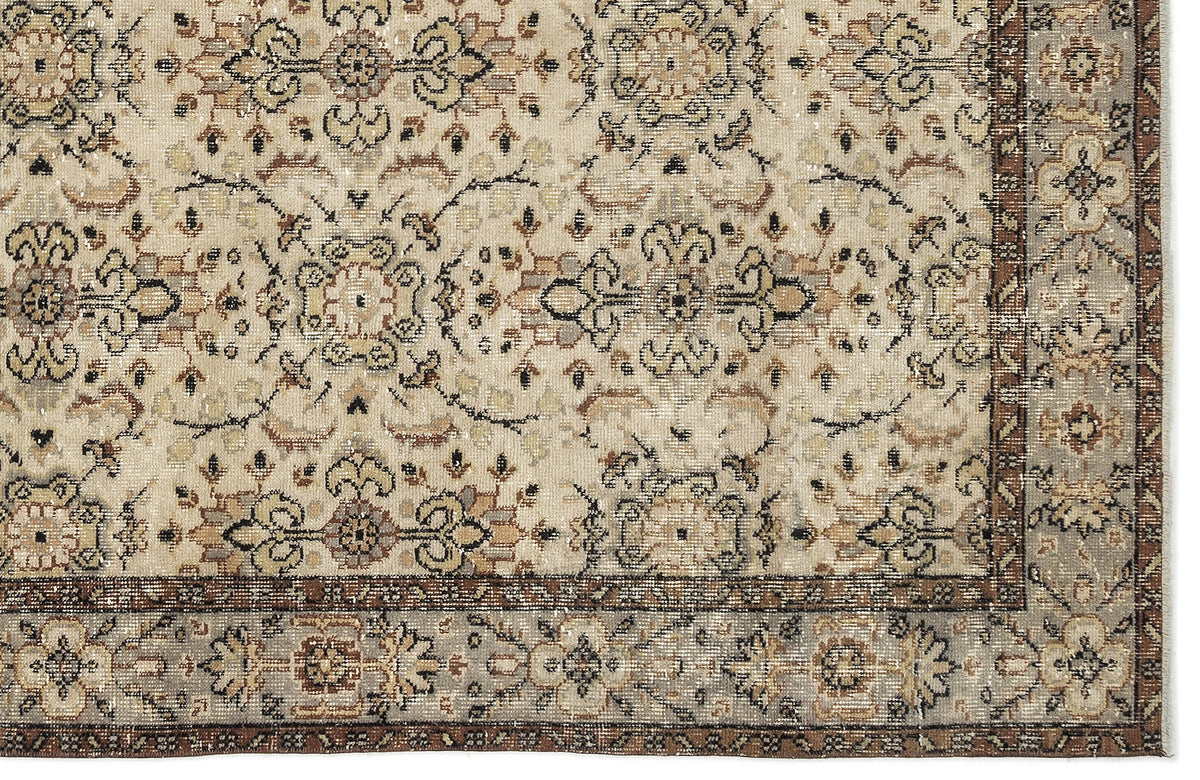 Beige and brown traditional rug with a distressed floral medallion pattern and a detailed border.