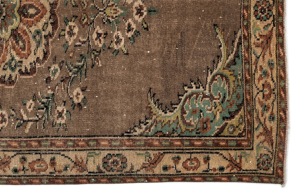 Brown traditional rug with a floral medallion pattern in teal, cream, and rust, featuring a detailed decorative border.