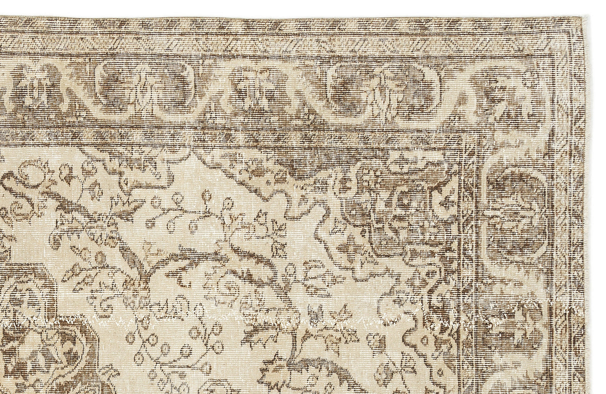 A close-up of the Tribuva Vintage Medallion Rug (6'3 x 9'6) highlights its intricate floral and geometric patterns in beige and brown, featuring detailed border and central medallion designs.