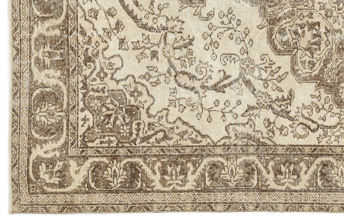 A close-up of the Tribuva Vintage Medallion Rug (6'3" x 9'6") highlights its beige and brown tones, intricate floral and geometric borders, and detailed vintage-inspired pattern for an antique, elegant look.