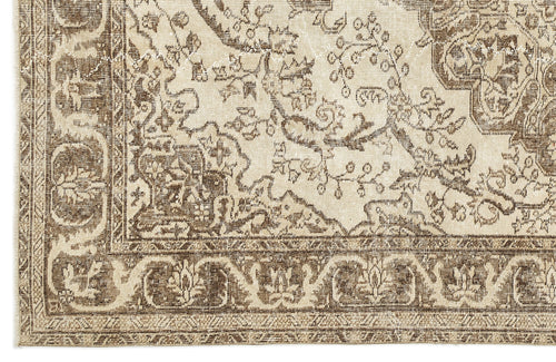 Load image 1 in gallery view. A close-up of the Tribuva Vintage Medallion Rug (6'3" x 9'6") highlights its beige and brown tones, intricate floral and geometric borders, and detailed vintage-inspired pattern for an antique, elegant look.
