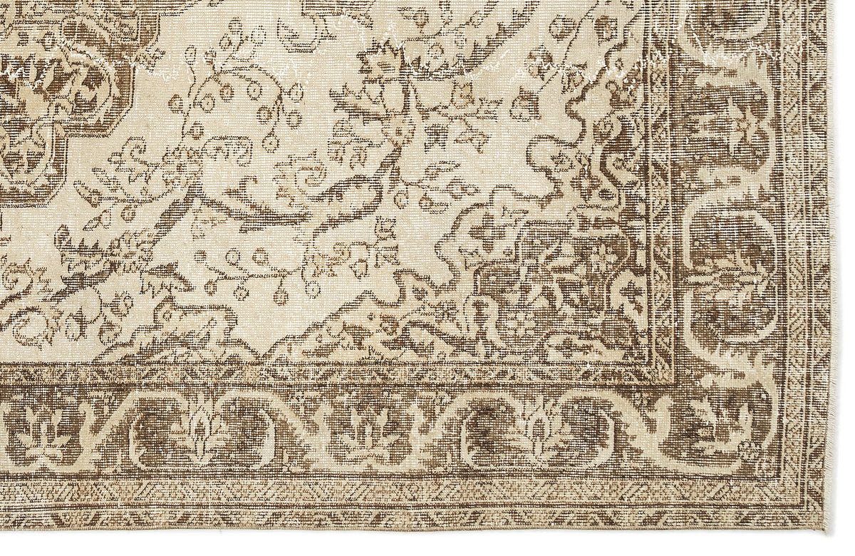 A close-up of the Tribuva Vintage Medallion Rug (6'3" x 9'6"), showcasing its rectangular shape, traditional floral and vine motifs in beige and brown, decorative border, and intricate vintage-inspired detailing.