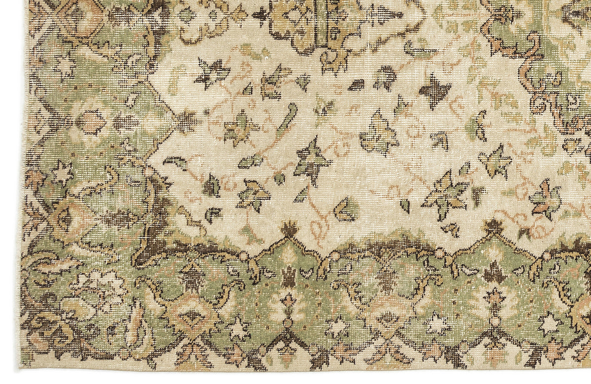 Distressed cream rug with sage green and brown traditional floral medallion pattern.