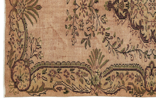 Load image 1 in gallery view. Tan vintage-style rug with a distressed floral border and central botanical motifs in olive green and dark brown.