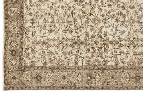 Load image 1 in gallery view. Beige and brown distressed rug with a repeating floral medallion pattern and a decorative border.