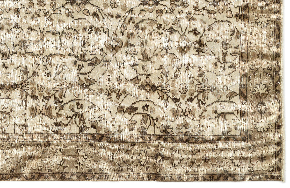 Beige and brown vintage-style rug with a distressed floral medallion pattern and a decorative border.