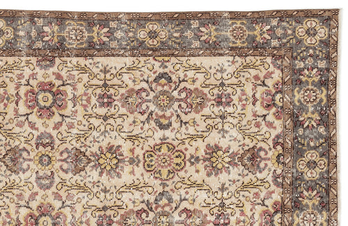 Load image 1 in gallery view. Beige traditional rug with a distressed floral medallion pattern and a dark grey border on a white background.