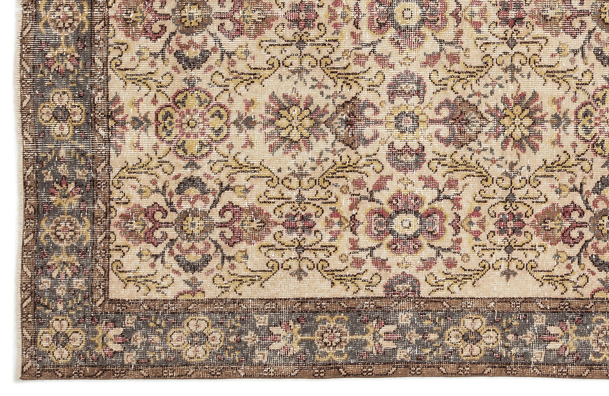 Beige traditional rug with a distressed floral medallion pattern and a dark brown border.