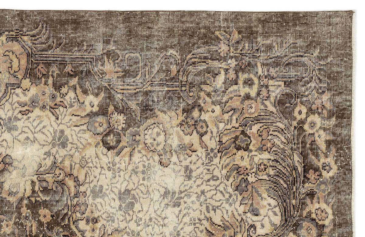 Dark brown traditional rug with a distressed floral medallion pattern in muted beige, grey, and soft pink tones.