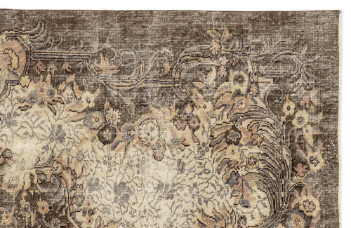 Load image 1 in gallery view. Dark brown traditional rug with a distressed floral medallion pattern in muted beige, grey, and soft pink tones.