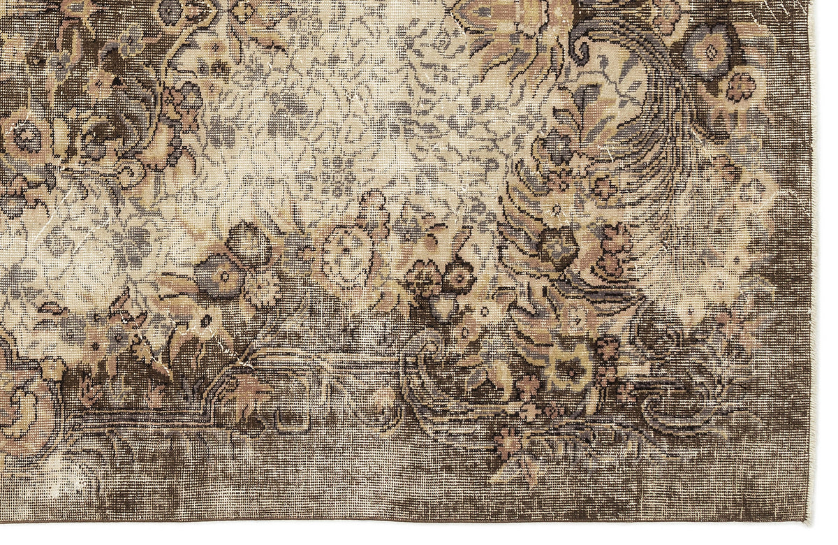 Distressed brown and cream rug with a faded traditional floral medallion pattern.