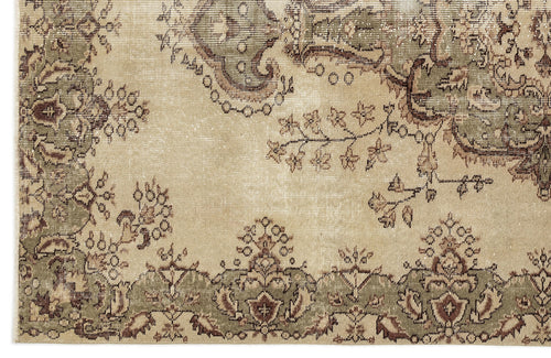 Load image 1 in gallery view. A section of the Clera - Vintage Medallion Rug (5'7 X 8'10) displays an ornate floral pattern with green and brown on beige, bordered by symmetrical motifs and intricate designs for a classic Anatolian look.