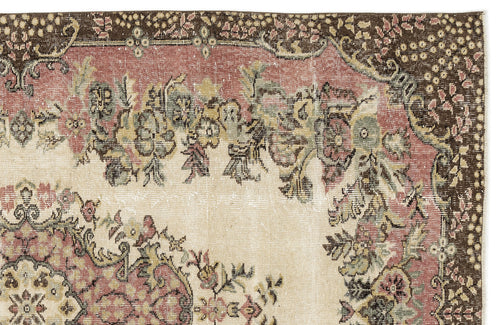 Load image 1 in gallery view. Distressed vintage-style rug with a floral medallion pattern in muted pink, sage green, and brown on a cream background.