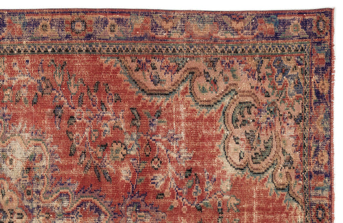 Load image 1 in gallery view. Distressed terracotta, blue, and beige rug with a traditional floral medallion pattern and a fringed edge.