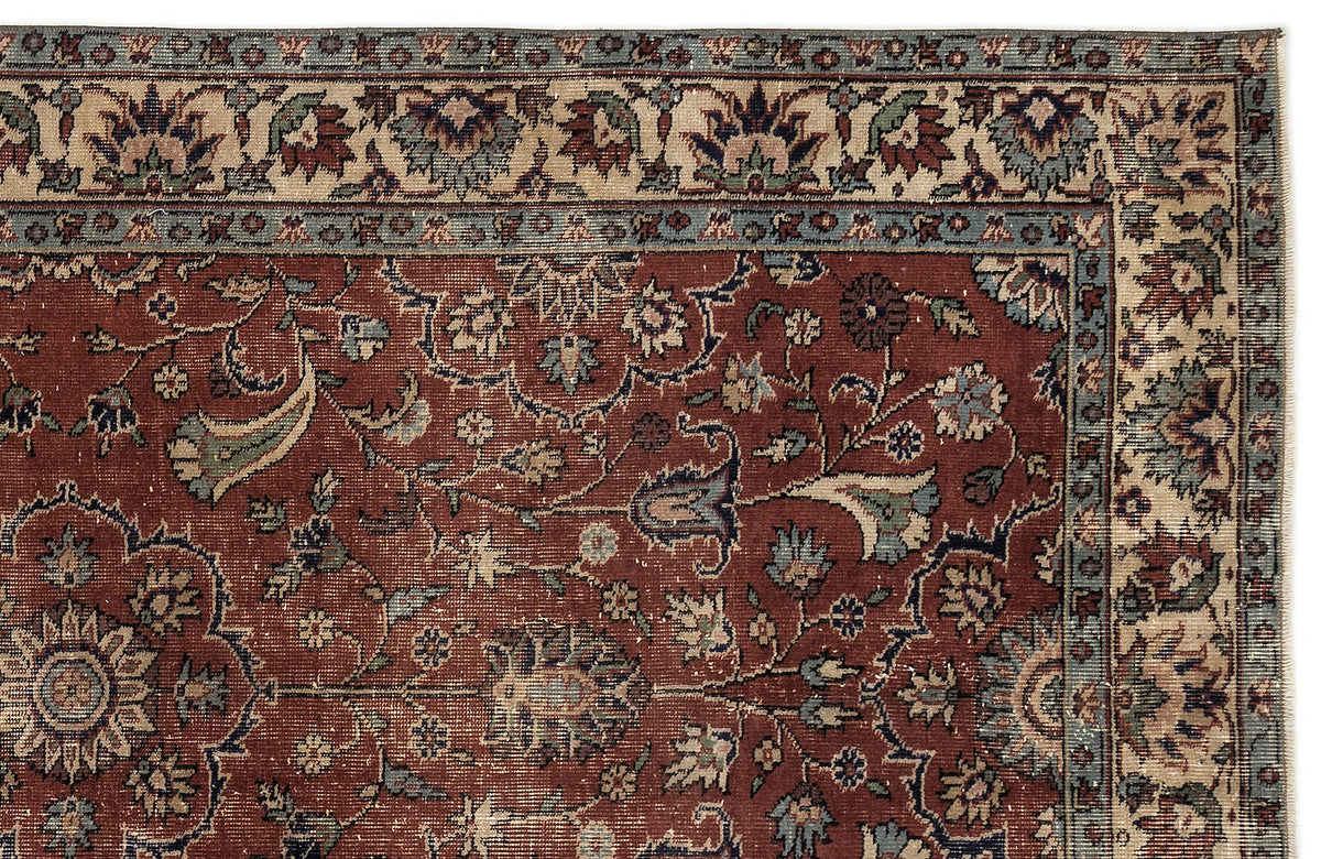 Traditional Persian-style rug with a deep red field, intricate floral vine patterns, and a multi-layered border.