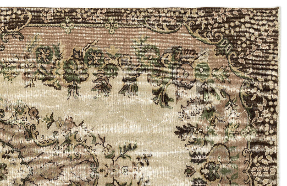 Distressed beige rug with a dark brown border and green and brown floral medallion pattern.