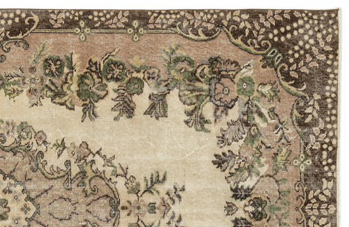 Load image 1 in gallery view. Distressed beige rug with a dark brown border and green and brown floral medallion pattern.