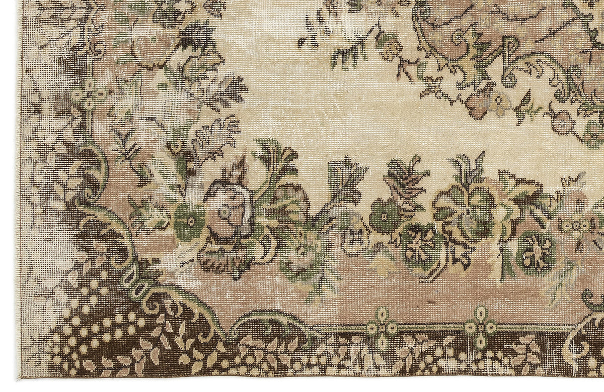 Distressed beige rug with a dark brown border and faded green and brown floral medallion pattern.