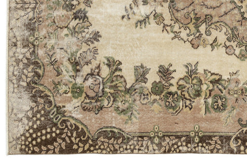 Load image 1 in gallery view. Distressed beige rug with a dark brown border and faded green and brown floral medallion pattern.