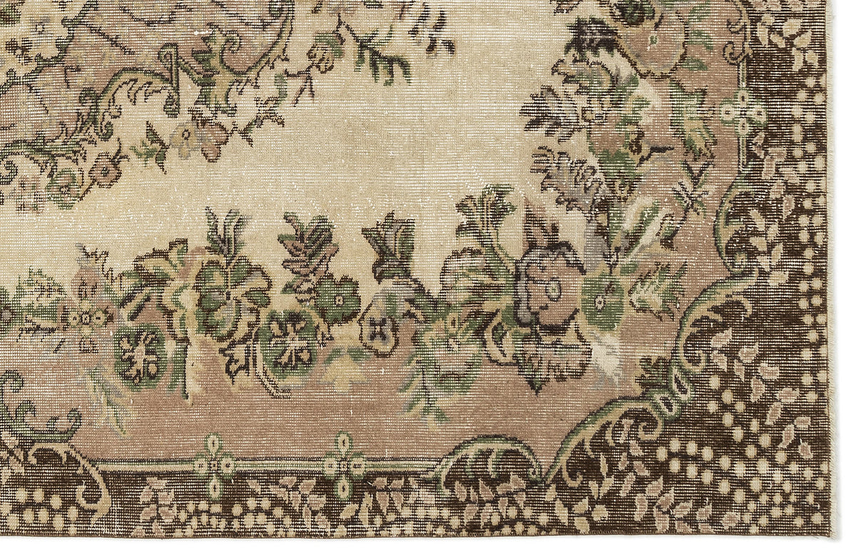 Beige, brown, and green vintage-style rug with a distressed floral medallion pattern and a dark border.