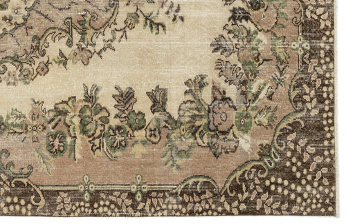 Load image 1 in gallery view. Beige, brown, and green vintage-style rug with a distressed floral medallion pattern and a dark border.