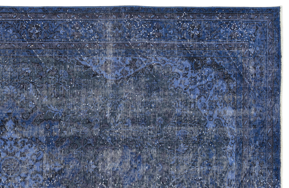 Deep blue distressed rug with a traditional floral medallion pattern and a bordered edge.