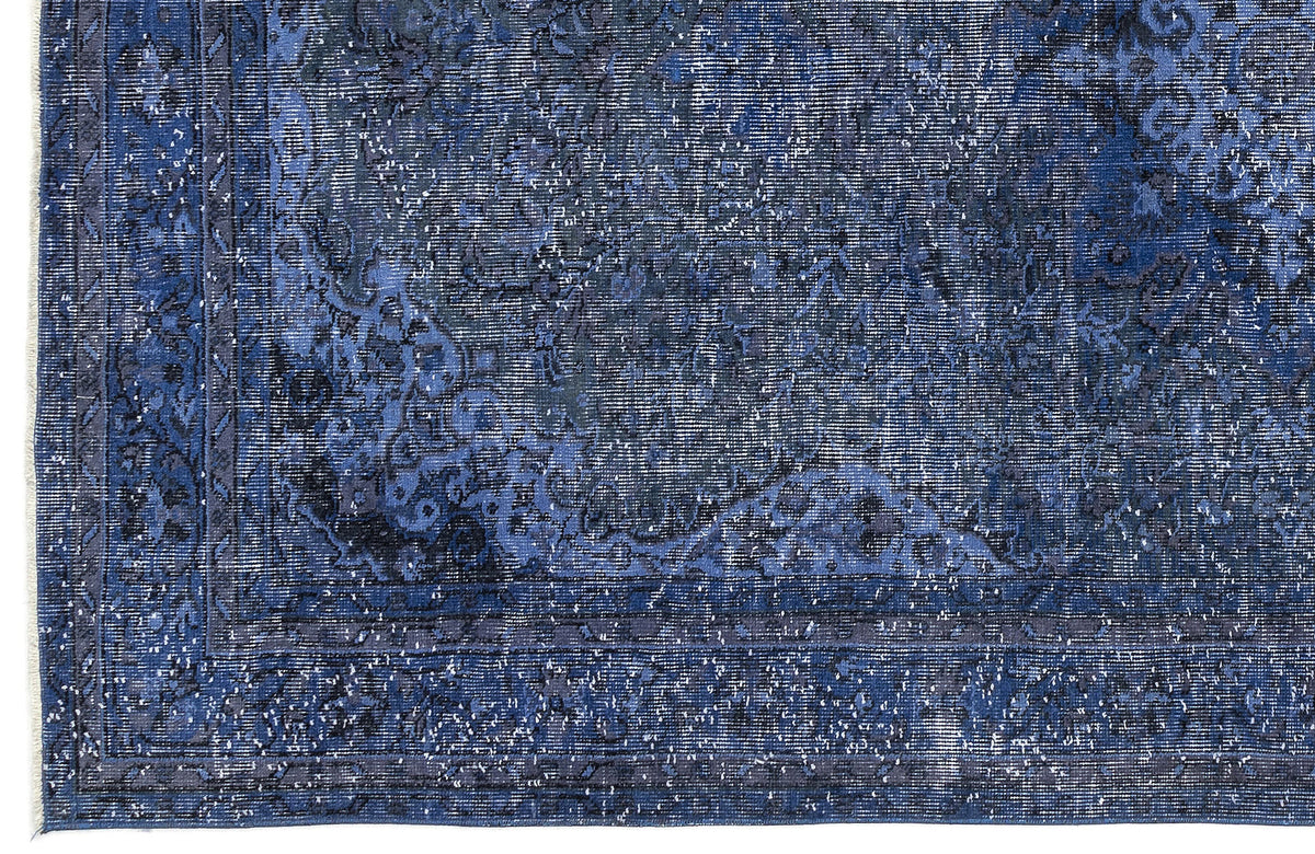 Deep blue and charcoal distressed rug with a traditional ornate medallion pattern and a detailed border.
