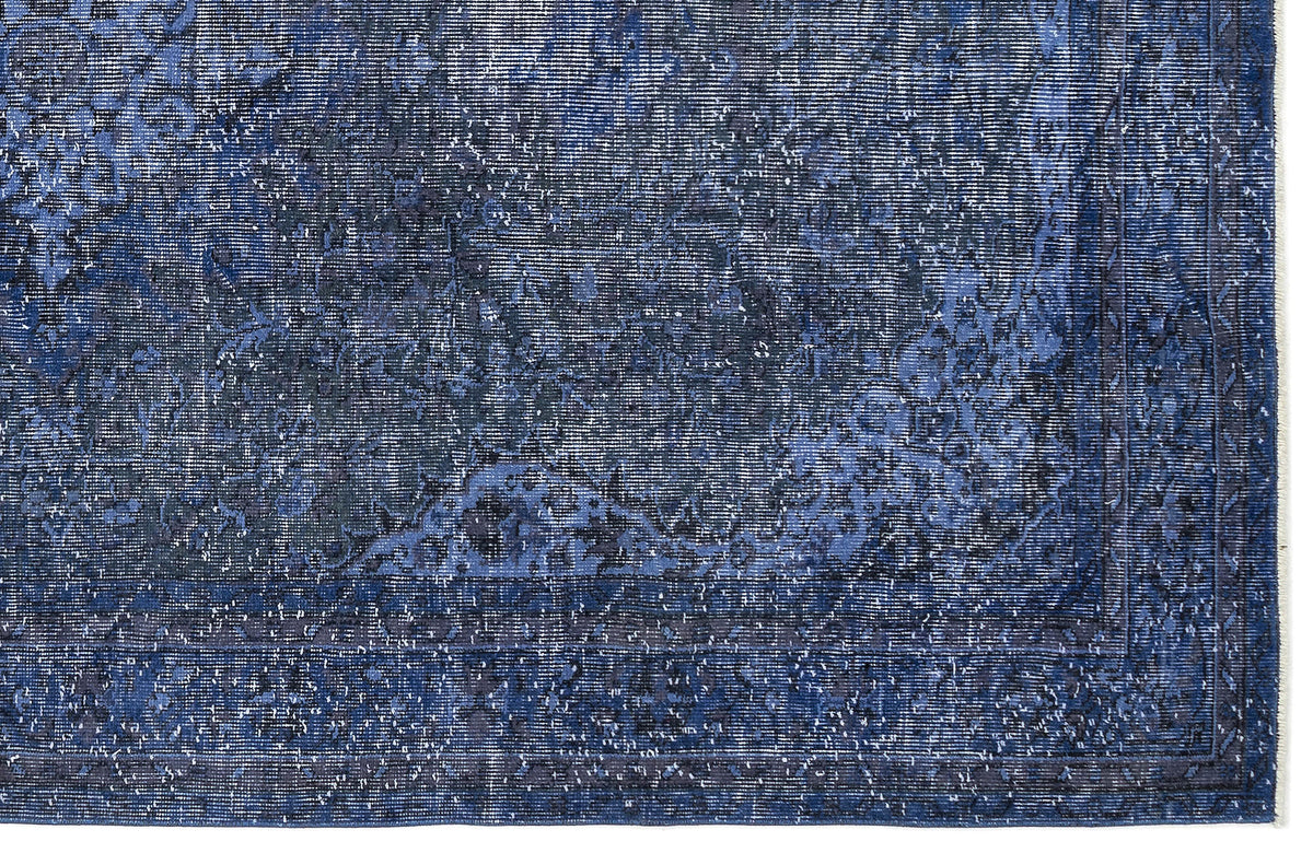 Deep blue distressed rug with a faded traditional floral medallion pattern and a bordered edge.