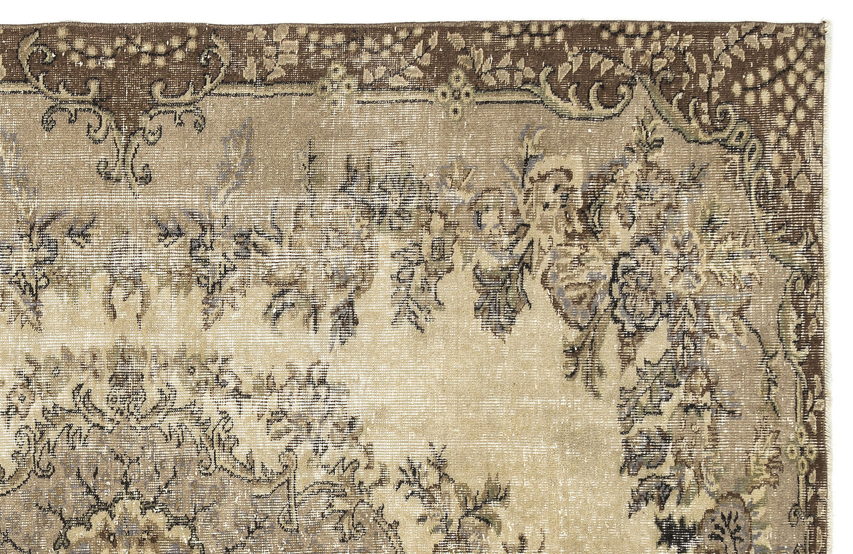 Distressed brown and beige vintage-style rug with a floral medallion pattern and a decorative border.