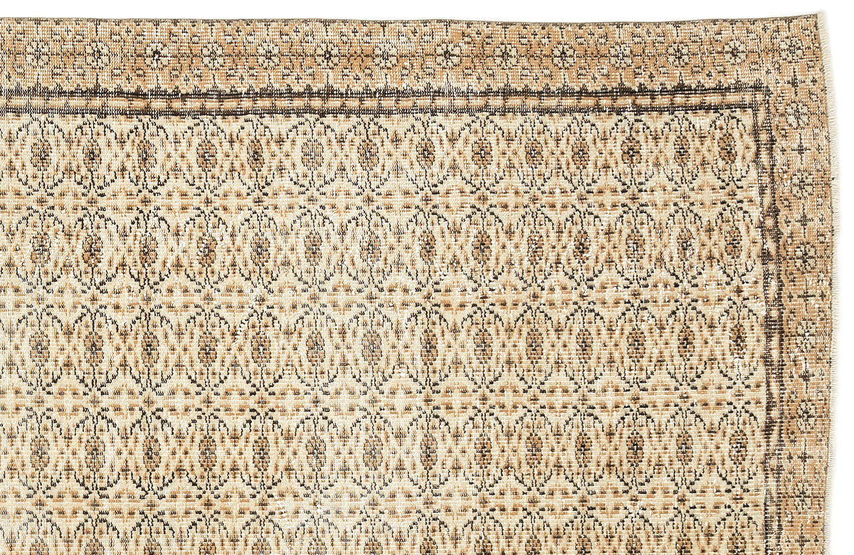 Tan and brown vintage-style rug with a repeating geometric medallion pattern and a decorative border.
