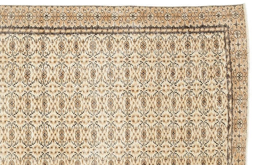 Load image 1 in gallery view. Tan and brown vintage-style rug with a repeating geometric medallion pattern and a decorative border.