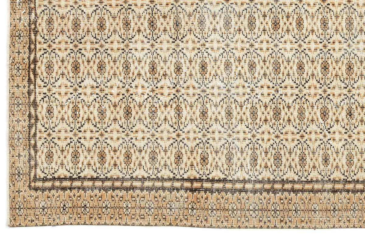 Beige and brown rug with a repeating geometric diamond and floral medallion pattern and a dark border.