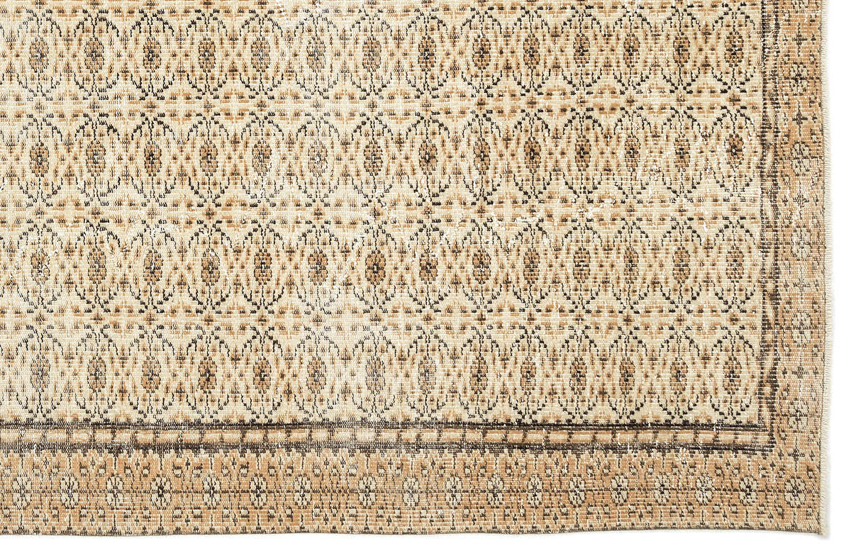 Tan and brown rug with a repeating geometric medallion pattern and a decorative border.