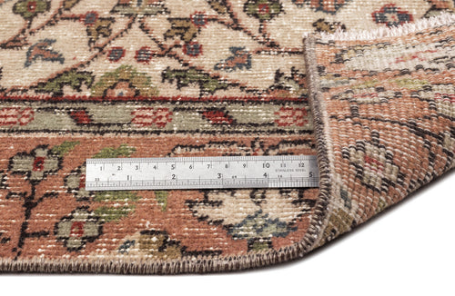 Load image 1 in gallery view. Beige, terracotta, and green traditional floral rug with a folded corner and a metal ruler for scale.