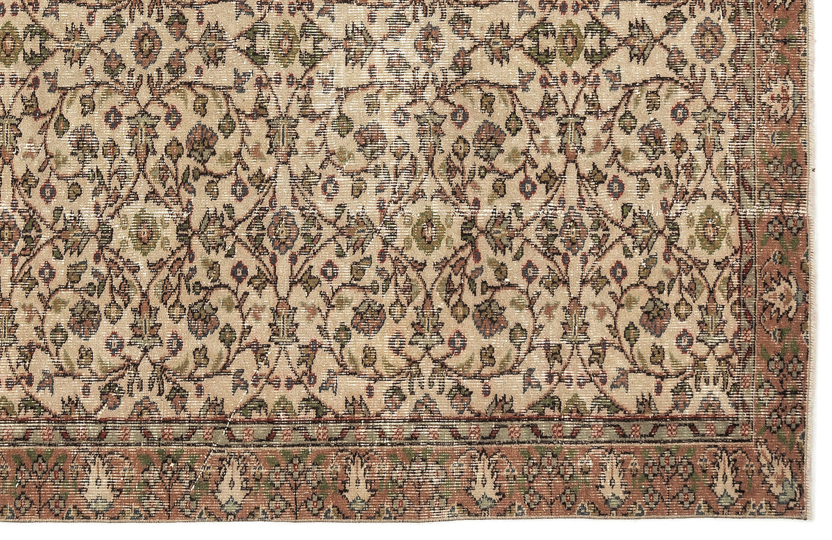 Beige traditional rug with a distressed floral vine pattern in muted green, red, and blue tones.