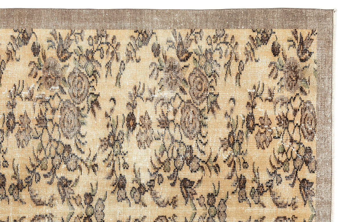Distressed beige rug with a brown floral pattern and a solid brown border on a white background.