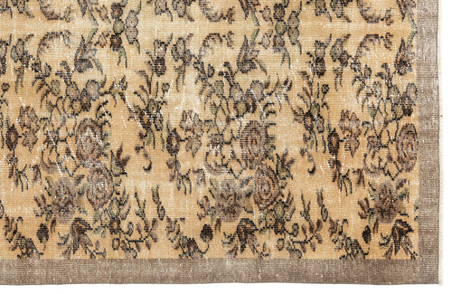 Load image 1 in gallery view. Tan and brown distressed rug with a faded floral pattern and a solid border.