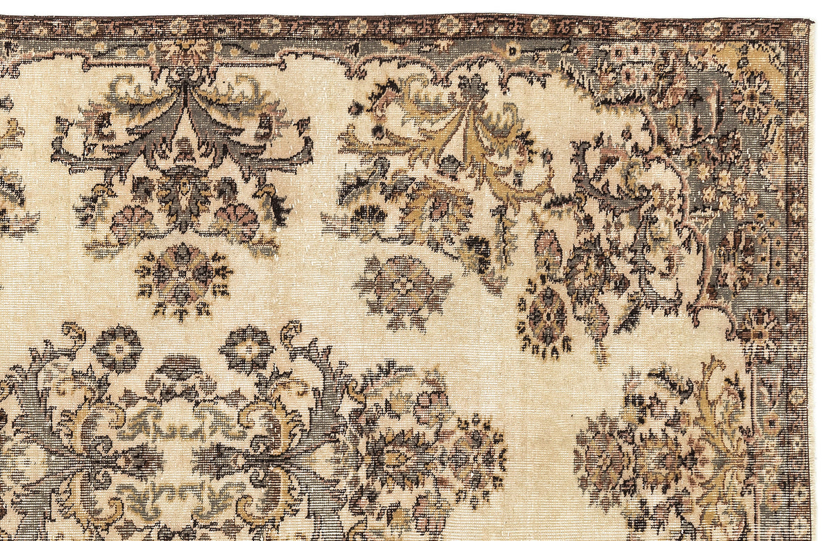 Beige rug with a distressed traditional floral medallion pattern in charcoal, olive, and muted pink tones.