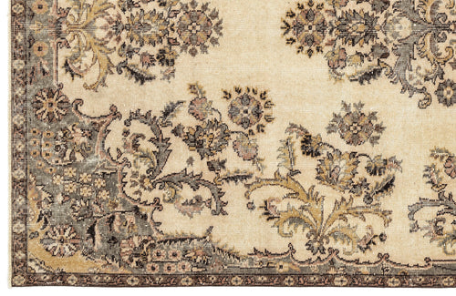 Load image 1 in gallery view. Beige rug with a distressed floral medallion pattern in muted charcoal, olive, and dusty rose tones.