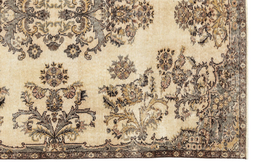 Load image 1 in gallery view. Beige rug with a distressed, dark brown and muted green floral medallion pattern and a decorative border.