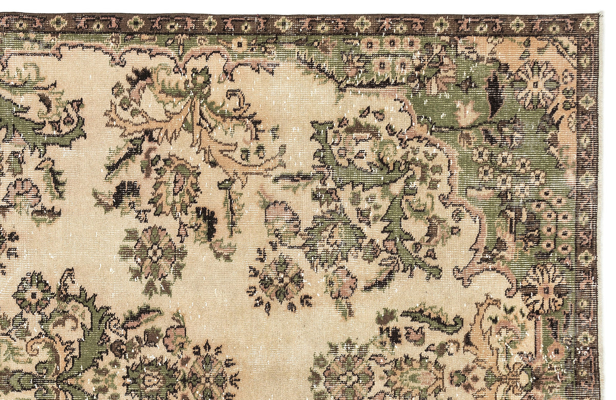 Distressed beige rug with a dark brown border and green and pink floral medallion pattern.