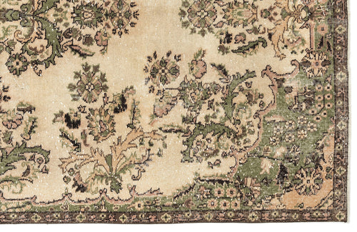 Load image 1 in gallery view. Distressed beige rug with a faded green and brown floral medallion pattern and a dark border.